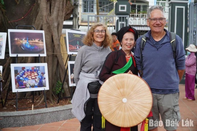 Du khách nước ngoài chụp ảnh lưu niệm cùng người dân địa phương tại Đình Lạc Giao (phường Buôn Ma Thuột).