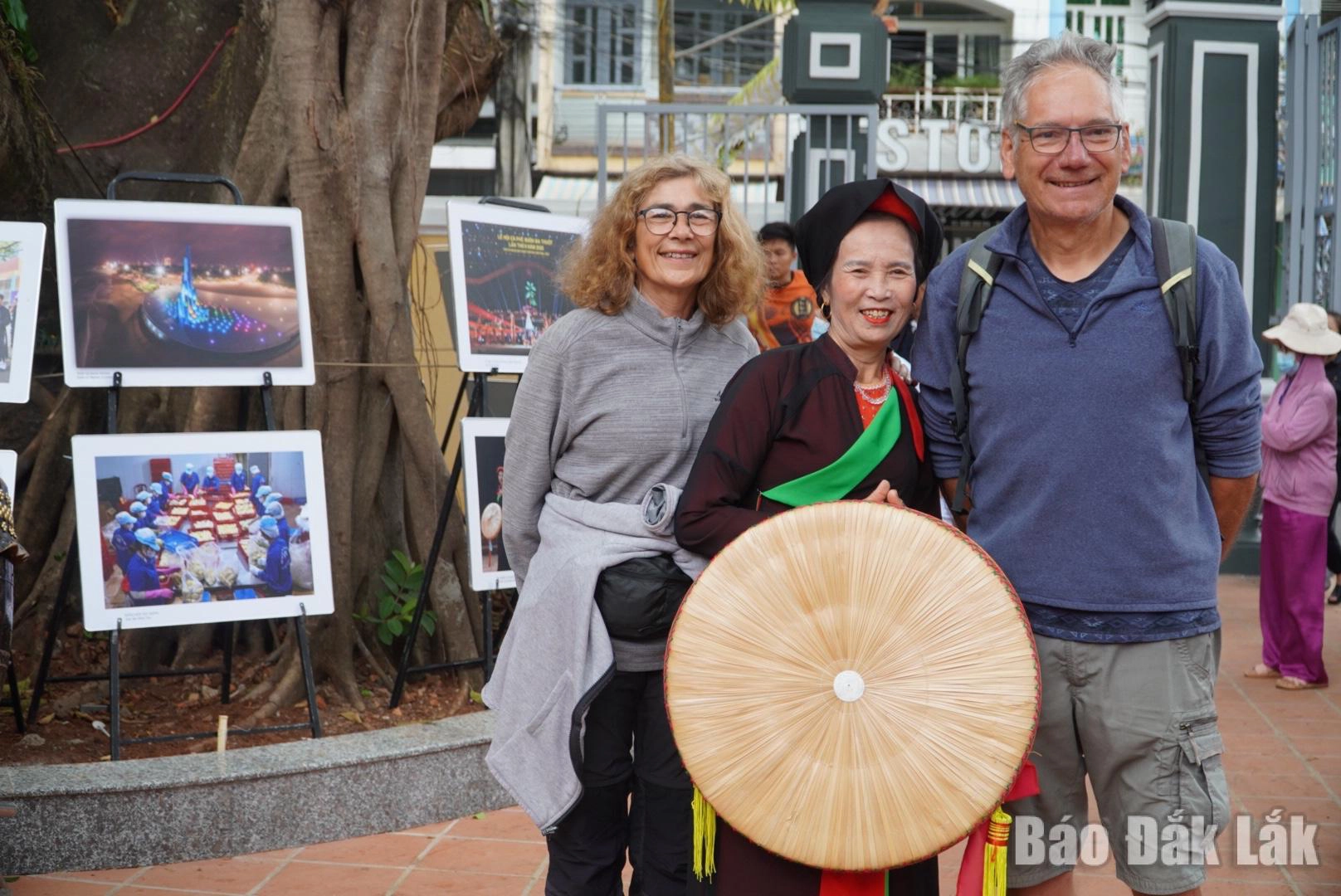 Du khách nước ngoài chụp ảnh lưu niệm cùng người dân địa phương tại Đình Lạc Giao (phường Buôn Ma Thuột).