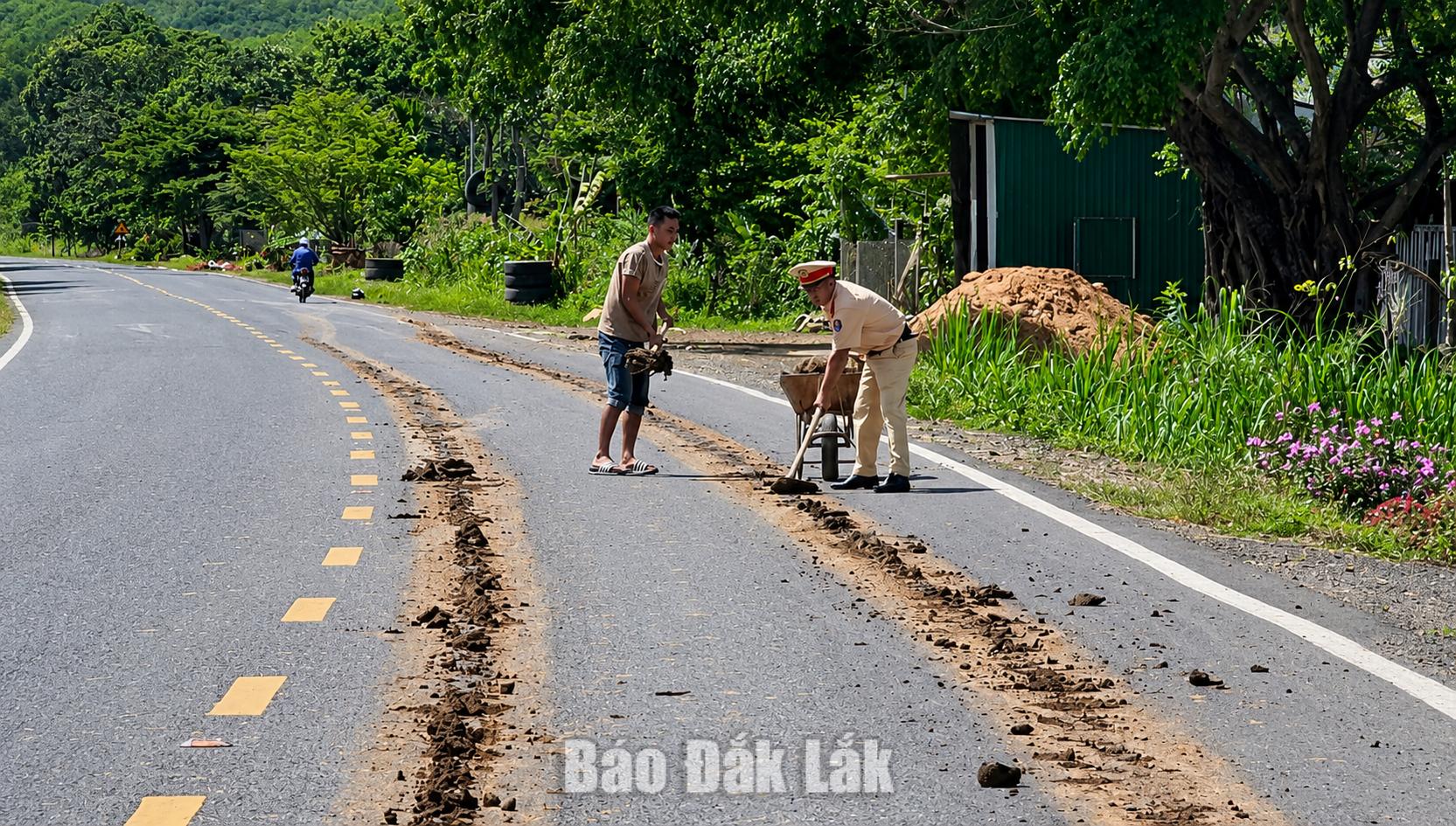 Lập biên bản xử phạt hành chính tài xế để đất cát rơi vãi trên đường 1 Cán bộ Đội CSGT đường bộ số 2 dọn dẹp đất cát rơi vãi trên đường.
