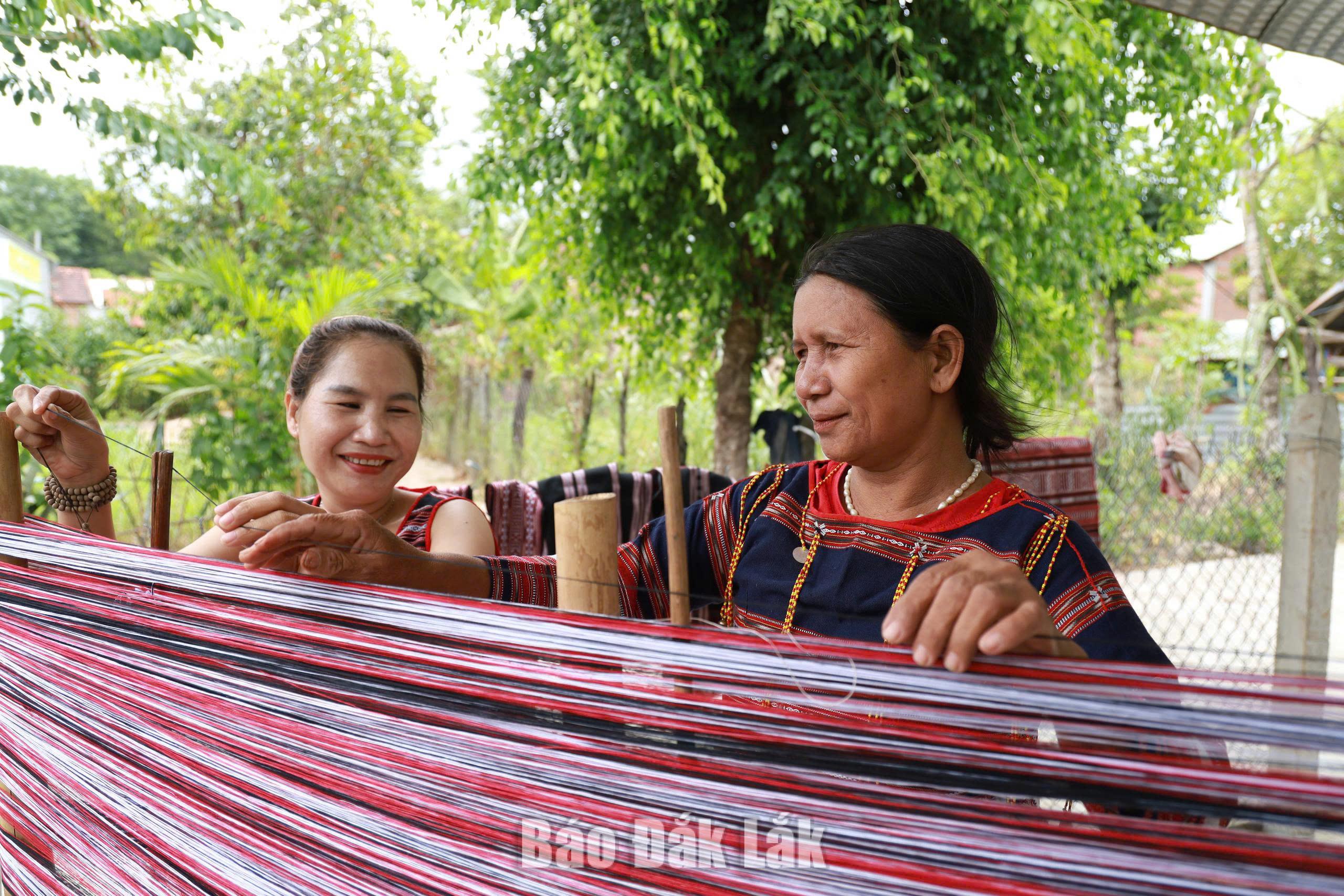 Sắc đỏ nghị quyết trên khung cửi Ba Na 3 Các nghệ nhân đang thực hiện công đoạn lên khung là khâu quan trọng nhất trước khi dệt thổ cẩm.