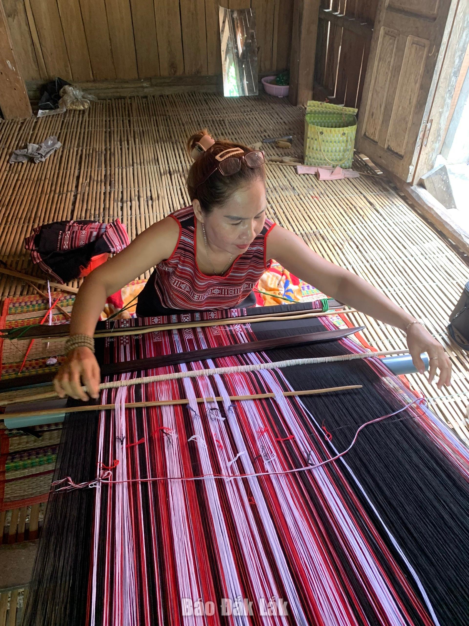 Sắc đỏ nghị quyết trên khung cửi Ba Na 4 Chị Lê Thị Thu Điền đang dệt thổ cẩm.