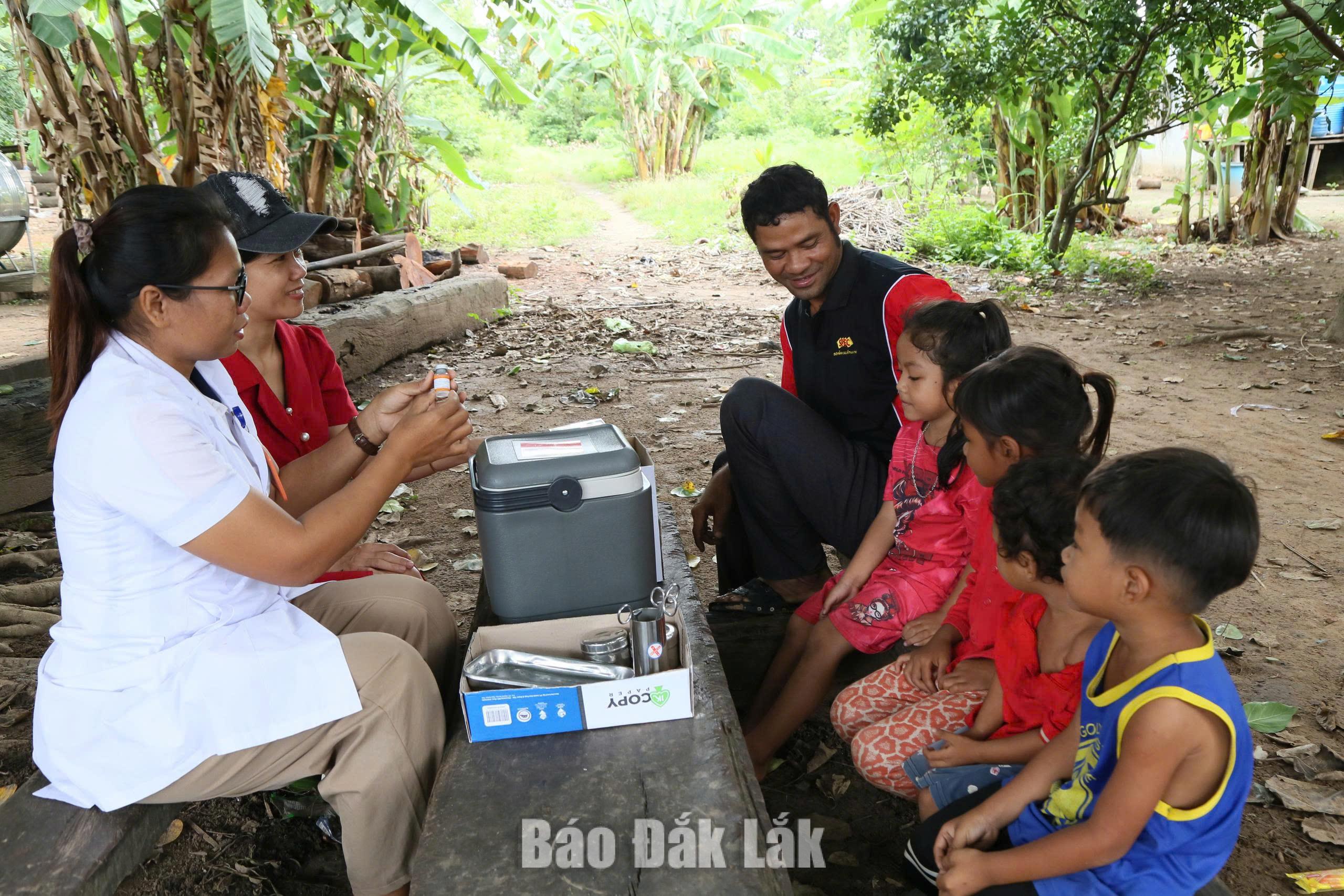 Người dân được cán bộ Trạm Y tế xã Buôn Đôn tư vấn, giới thiệu về vắc xin để tiêm cho trẻ. Ảnh: Đình Thi

