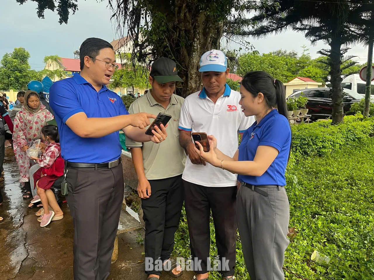 Đoàn viên thanh niên xã Quảng Phú hướng dẫn người dân thanh toán không dùng tiền mặt. 
